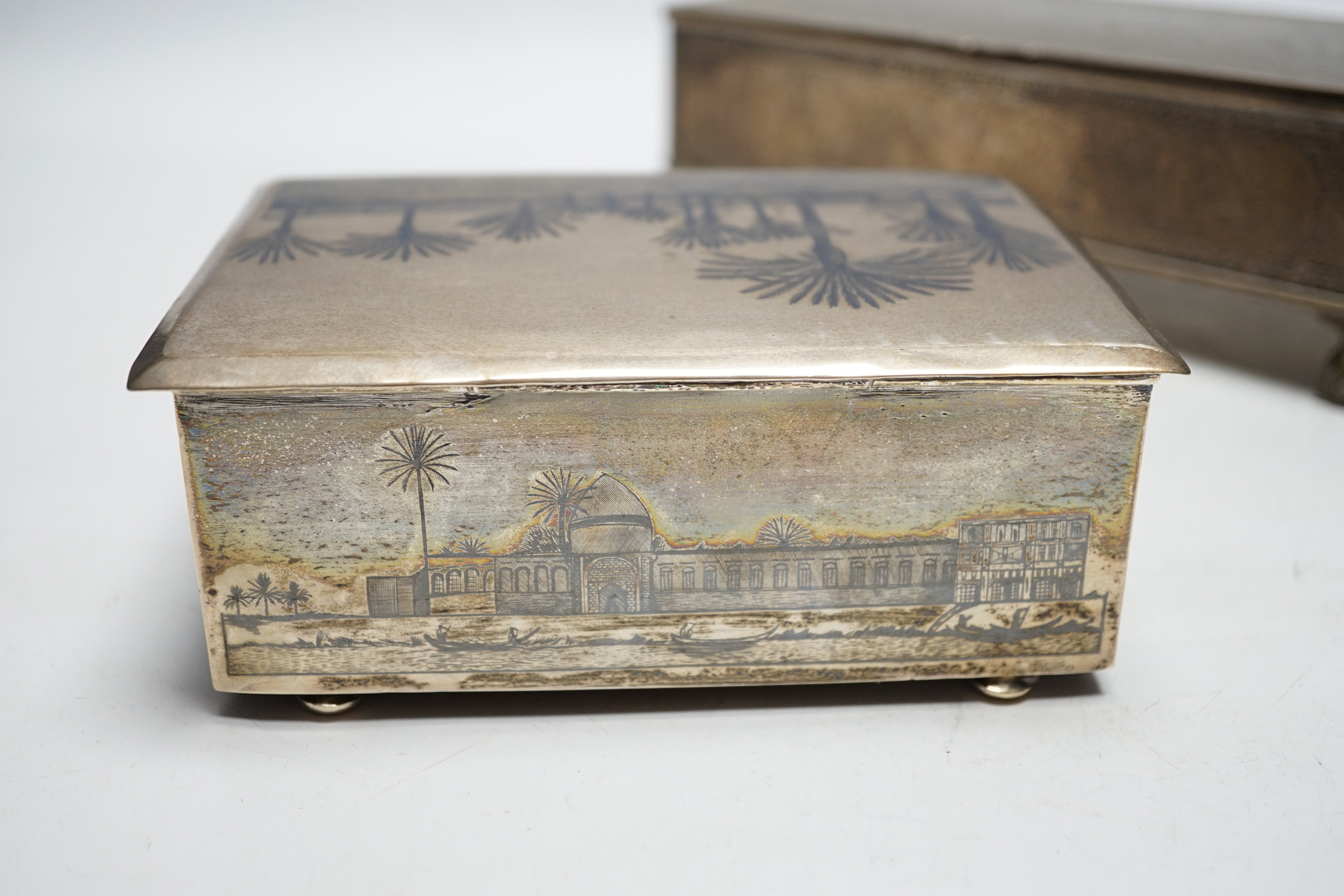 A Persian engraved white metal rectangular cigarette box and a similar white metal and niello cigarette box, largest 20.3cm.